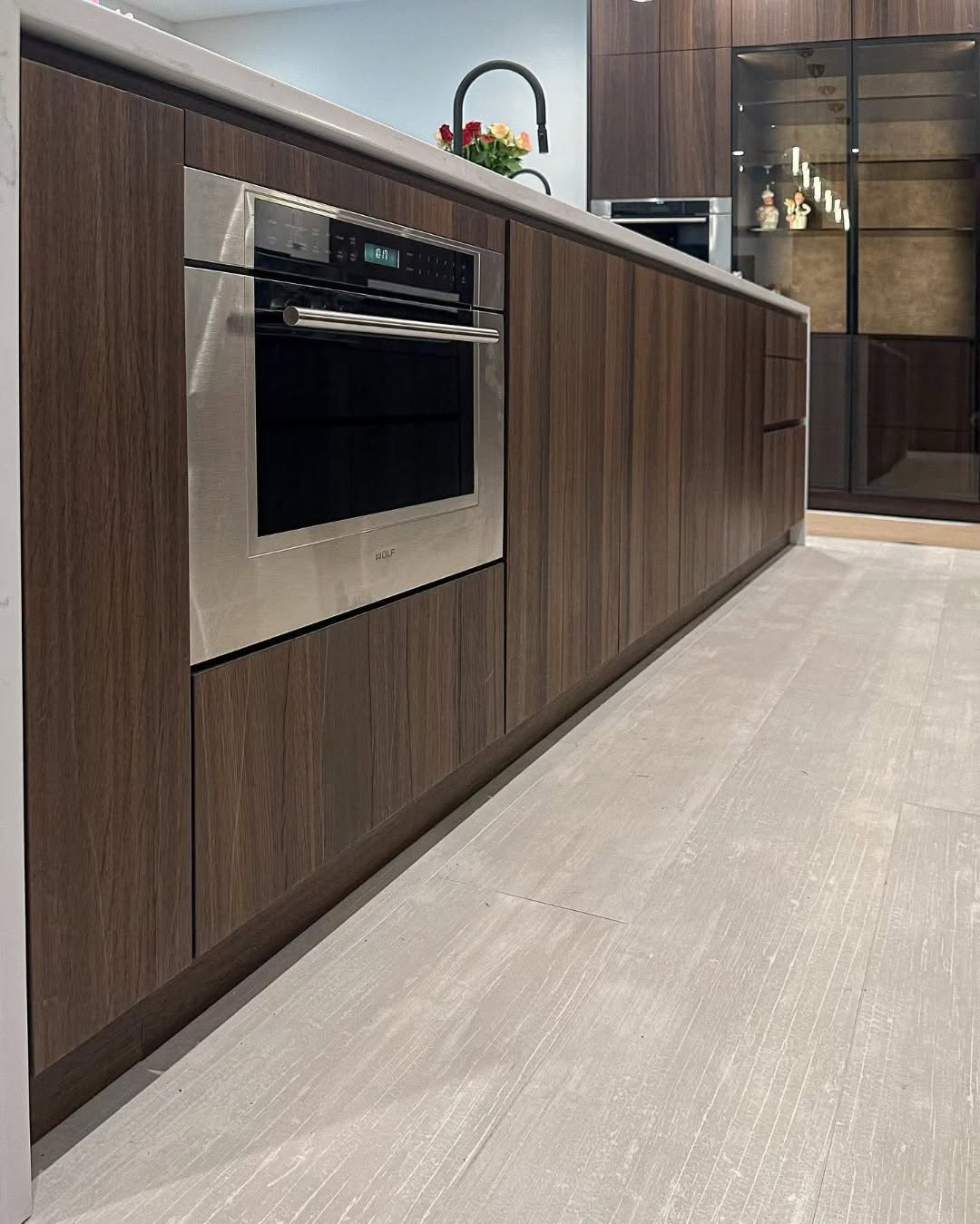 Handleless walnut cabinetry with integrated Wolf oven